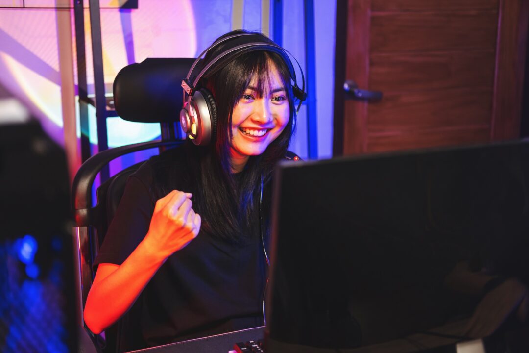 Happy asia girl gamer wear headphone competition play video game